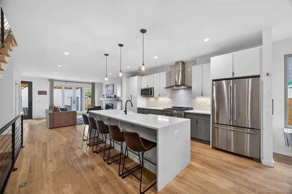 a kitchen with stainless steel appliances kitchen island granite countertop a stove top oven a sink and a refrigerator