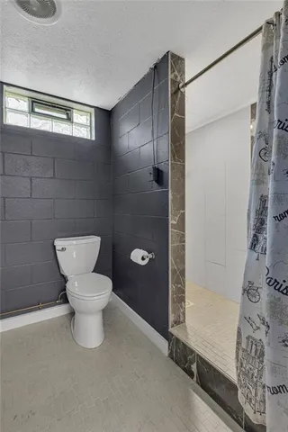 a bathroom with a toilet and a shower