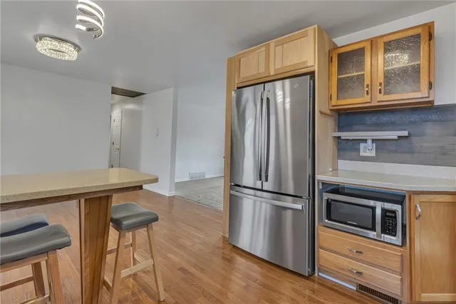 a kitchen with stainless steel appliances granite countertop a refrigerator and microwave