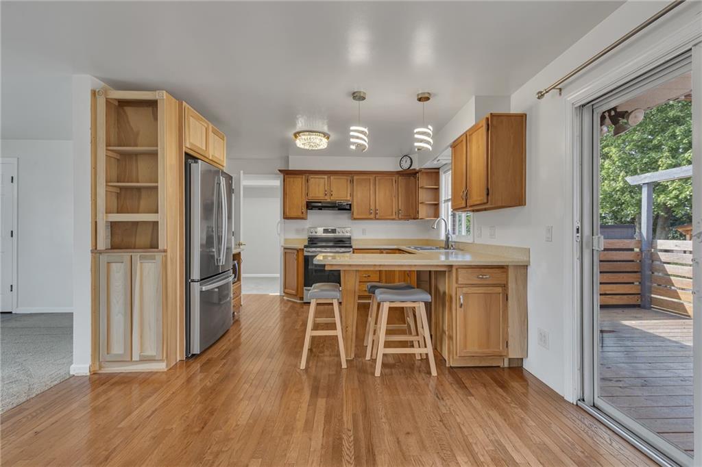 1044 Charles Street Monaca, PA 15061 - Photo 8 of 31 a kitchen with granite countertop a stove a sink dishwasher a refrigerator cabinets and wooden floor