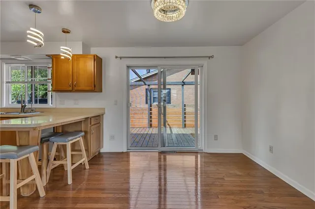 an empty room with wooden floor and cabinet