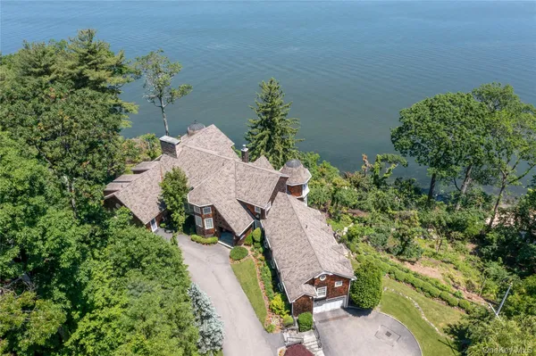 an aerial view of a house with a yard and lake view