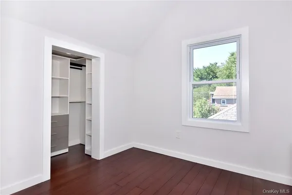 an empty room with wooden floor and a window
