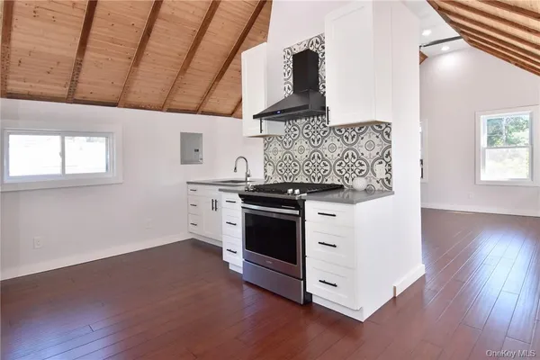 a kitchen with a stove and wooden floor