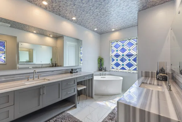 a large bathroom with a double vanity sink a mirror and a bathtub