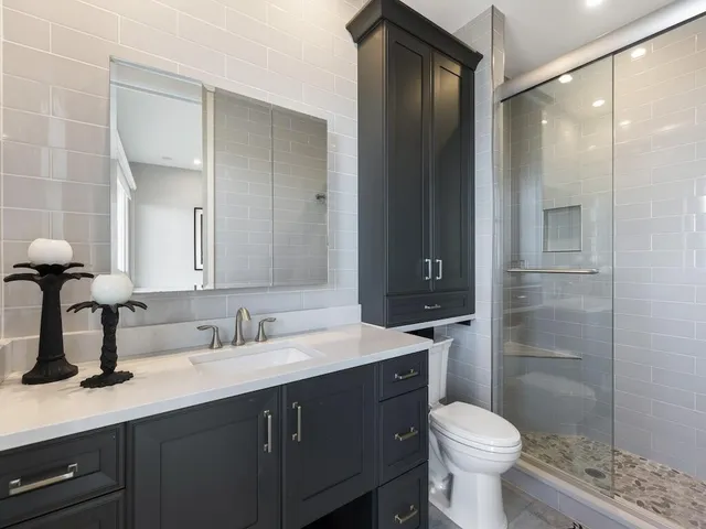 a bathroom with a sink toilet a mirror and shower