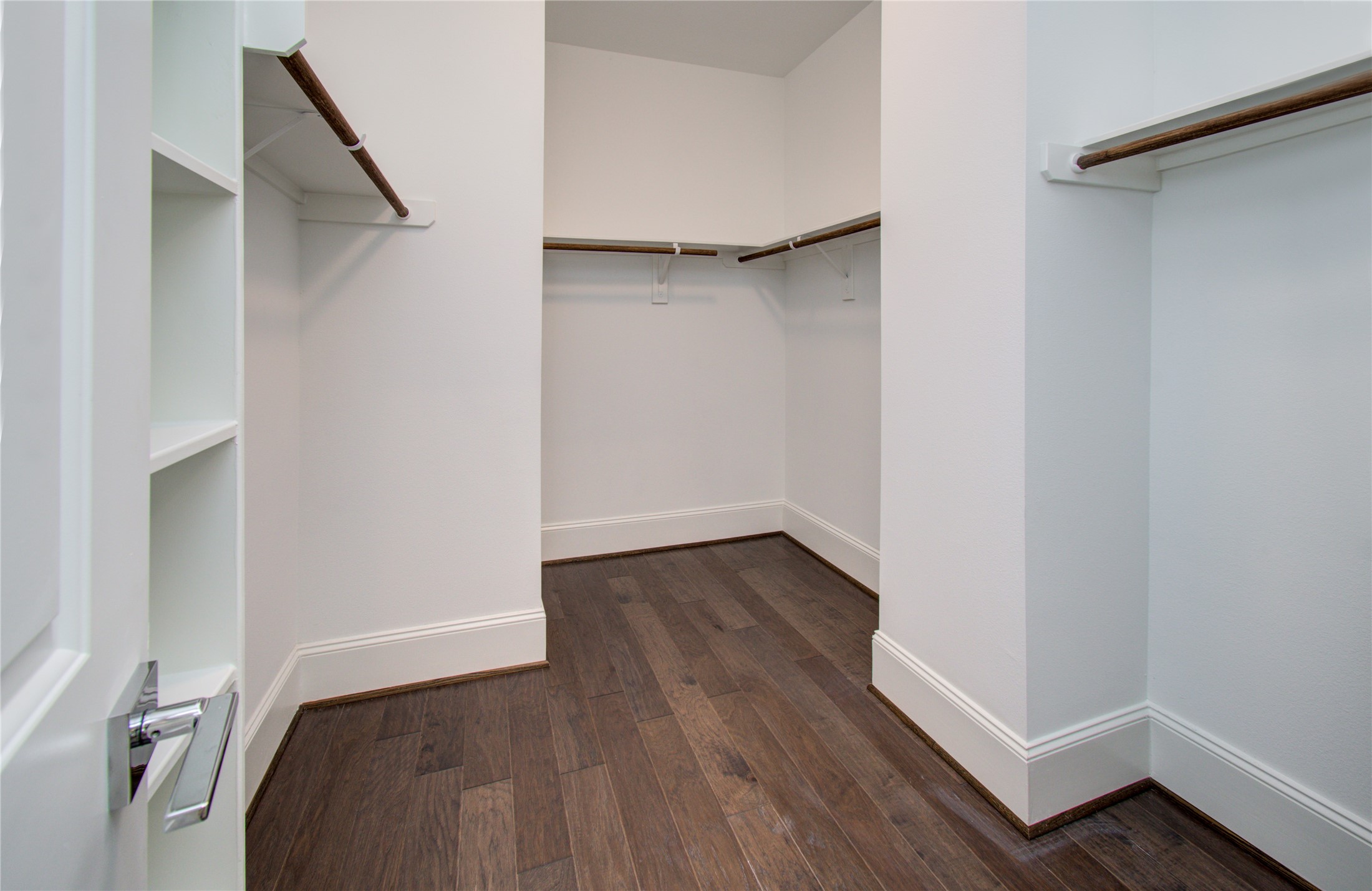 1262 North Post Oak Road, Unit A Houston, TX 77055 - Photo 40 of 50 Inside the walk-in closet, multiple levels of built-in hanging rods and integrated shelving units provide organized storage. Dark hardwood floors carry directly into the closet space.
