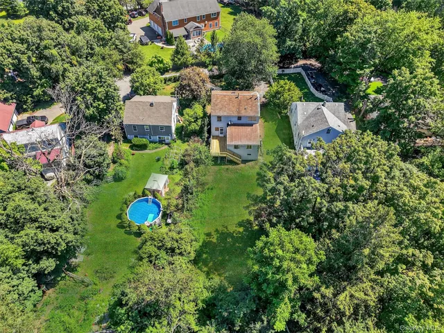 an aerial view of a house with a yard and trees