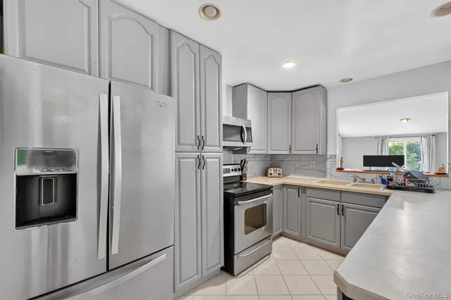 a kitchen with stainless steel appliances a refrigerator sink and microwave
