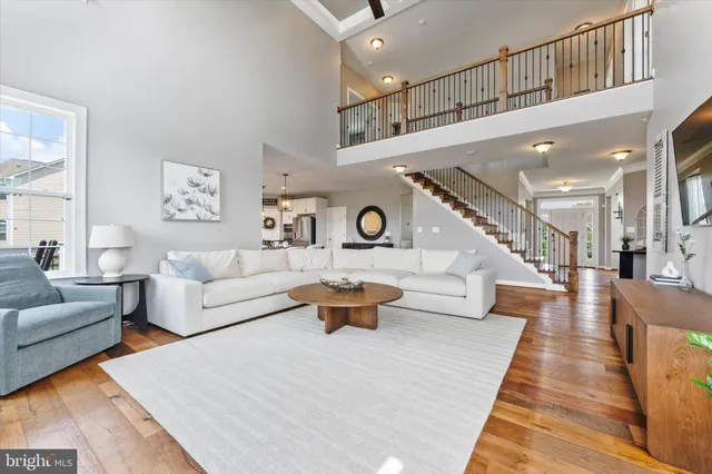 a kitchen with stainless steel appliances granite countertop a stove refrigerator a sink dishwasher a dining table and chairs with wooden floor