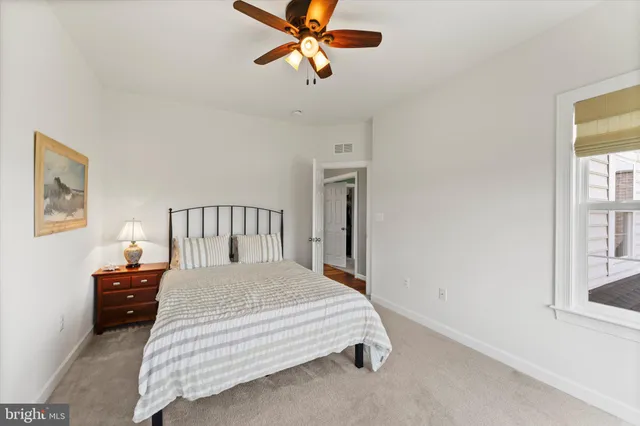 a kitchen with stainless steel appliances kitchen island granite countertop a dining table chairs and a refrigerator