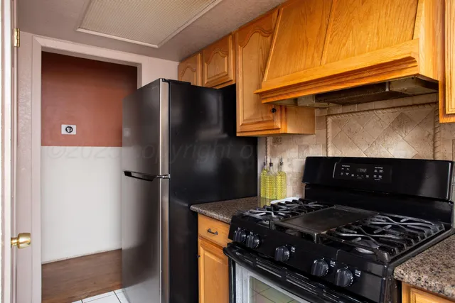 a kitchen with a sink a stove cabinets and a window