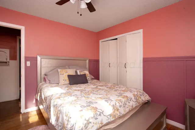 a bedroom with a bed and a mirror on the dresser