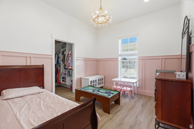 2013 South 100 West Perry, UT 84302 - Photo 21 of 49 Spacious room featuring wood-finish flooring, a chandelier fixture, and a built-in closet with shelving