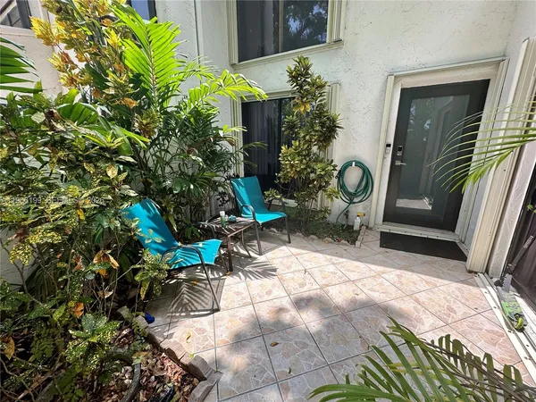 a view of backyard with a patio and plants