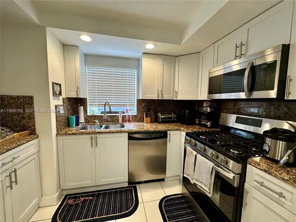 a kitchen with stainless steel appliances a sink dishwasher stove microwave and cabinets
