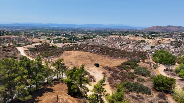 an aerial view of residential houses with outdoor space and trees