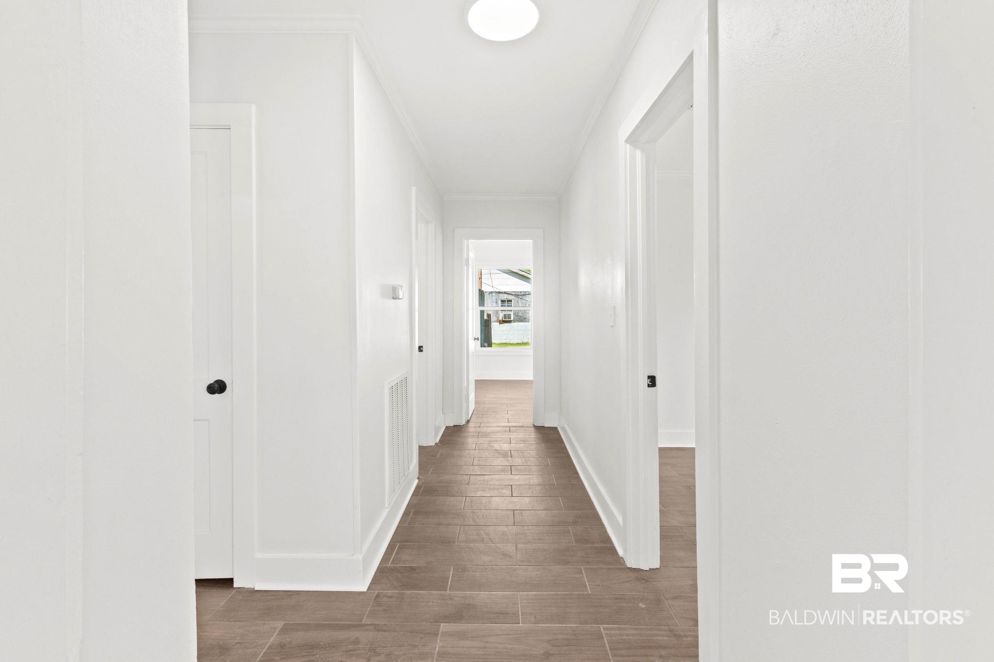 311 Cloverdale Road Atmore, AL 36502 - Photo 24 of 63 Hallway featuring wood-finish flooring, white walls, and white trim