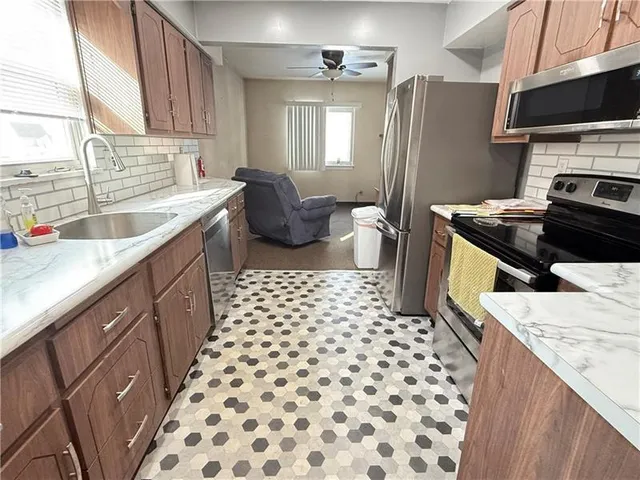 a kitchen with a sink a stove a refrigerator and a window