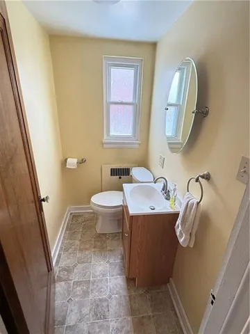 a bathroom with a granite countertop toilet sink and mirror