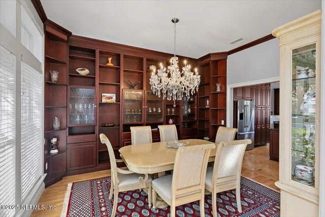 a dining room with furniture a chandelier and wooden floor