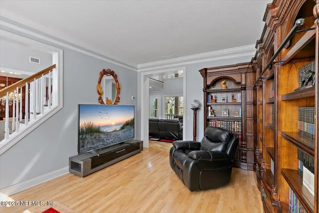 a living room with furniture and a large window with wooden floor