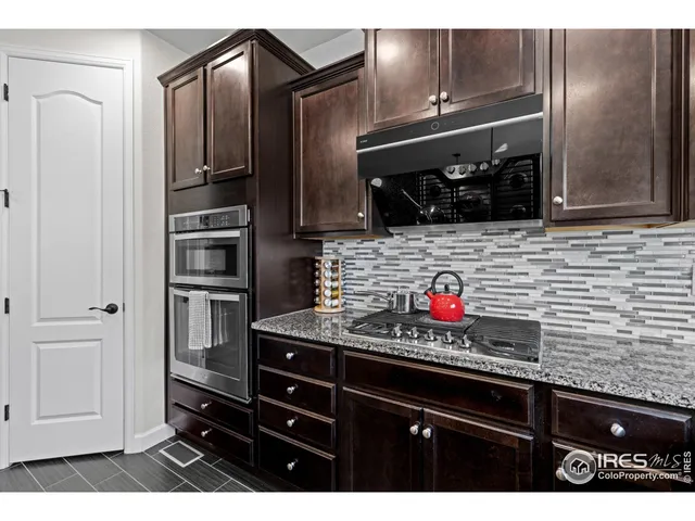 a kitchen with stainless steel appliances kitchen island granite countertop a refrigerator and a stove