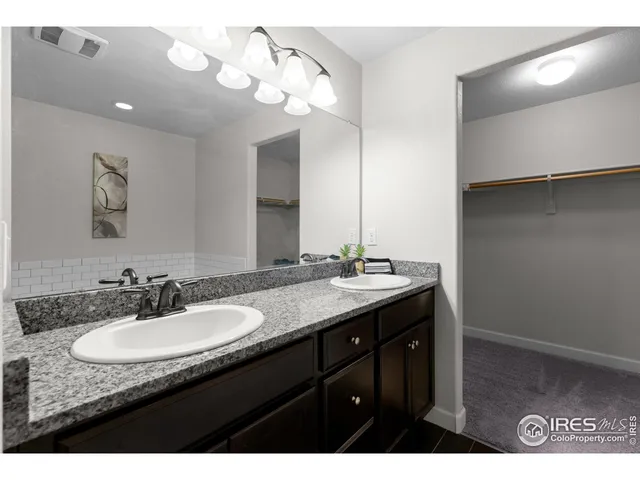 a bathroom with a granite countertop sink a light fixture and a mirror