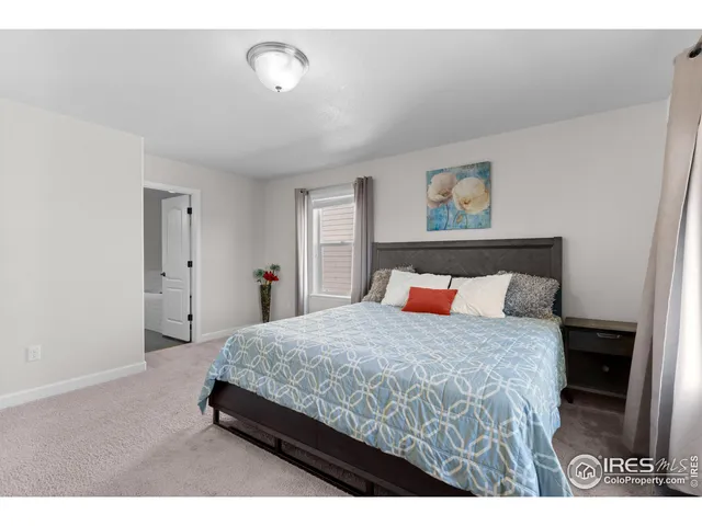 a bedroom with a bed and a painting on the wall