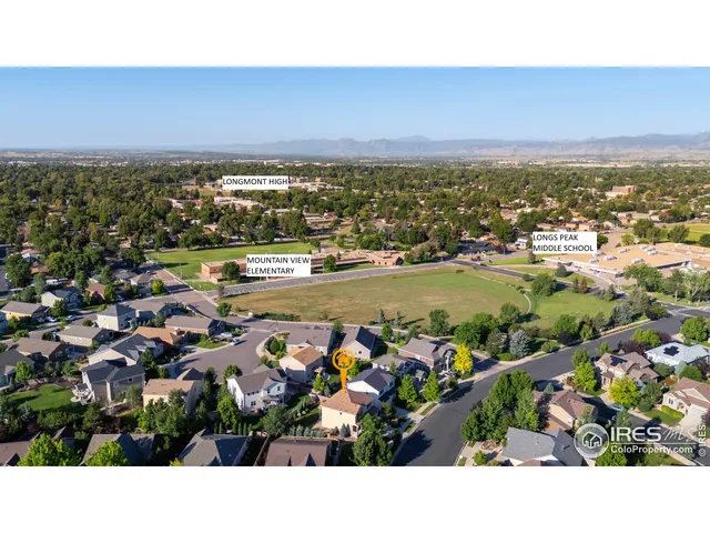 an aerial view of ocean and residential houses with outdoor space