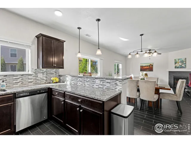 a kitchen with a sink chandelier and wooden floor