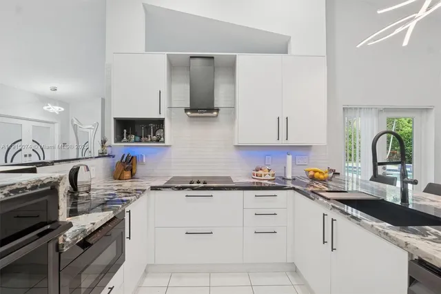 a kitchen with white cabinets and appliances