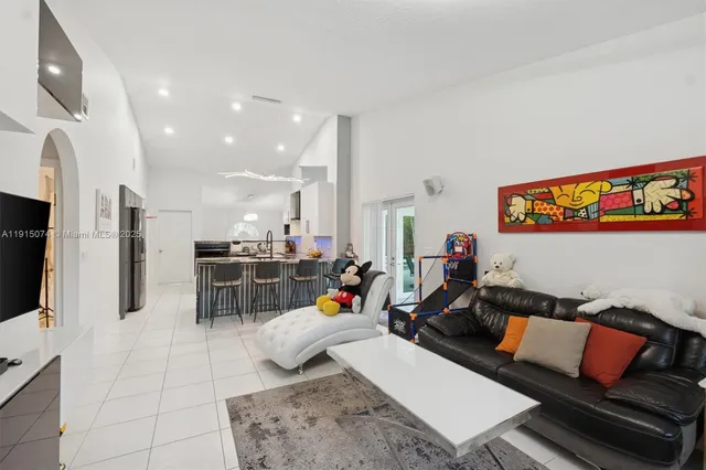 a living room with lots of furniture and kitchen view