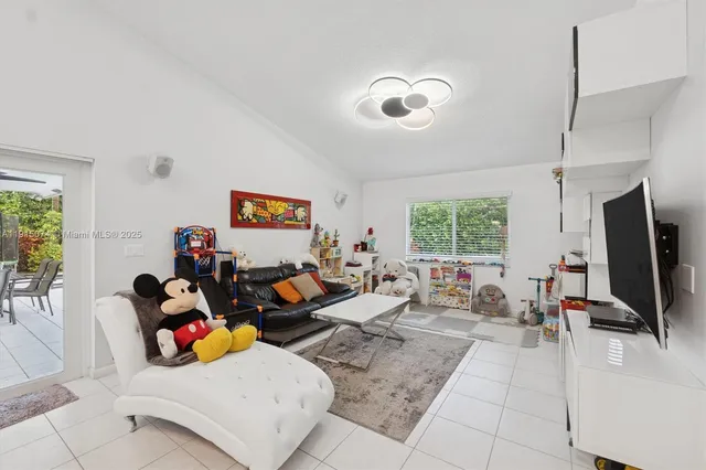 a living room with furniture a window and a flat screen tv