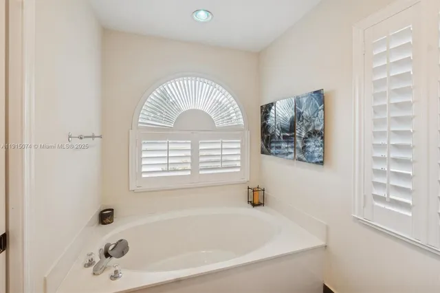 a bathroom with a bathtub and a window