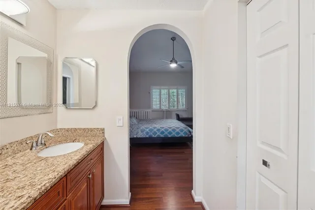 a en suite bathroom with a granite countertop sink and a mirror