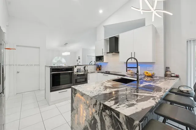a kitchen with a sink a stove and chairs