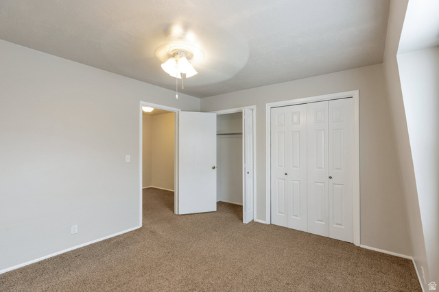 88 West 50 South, Unit J10 Centerville, UT 84014 - Photo 15 of 19 Carpeted room with light neutral walls, a bi-fold closet, and an overhead ceiling fan light fixture