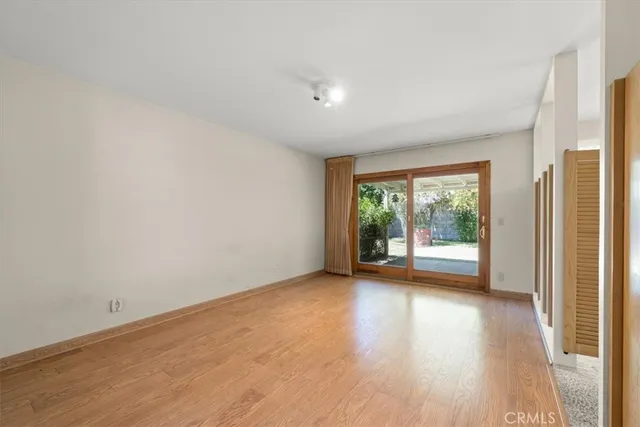a view of a big room with wooden floor and windows