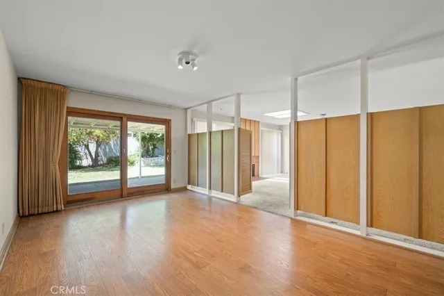 a view of a room with wooden floor and sliding glass door