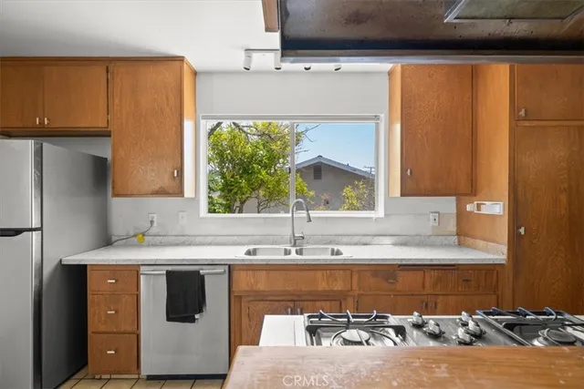a kitchen with kitchen island a sink a stove and a refrigerator