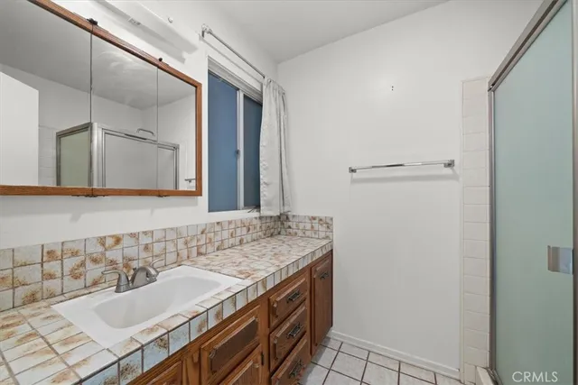 a bathroom with a granite countertop sink and a mirror