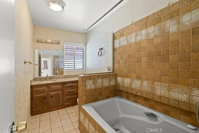 a bathroom with a bathtub shower sink vanity and toilet