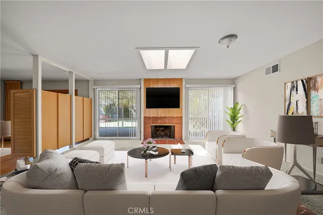 a living room with furniture a fireplace and a flat screen tv