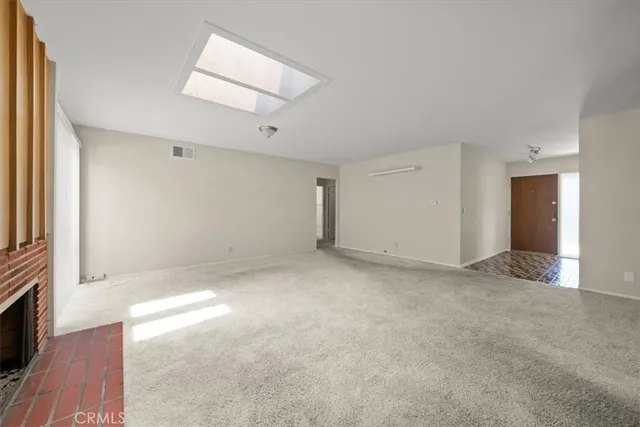 a view of a room with an empty space and a fireplace