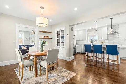 a view of a dining room and livingroom with furniture wooden floor a chandelier