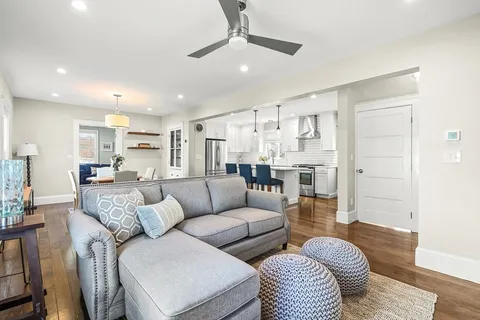 a living room with furniture and a view of kitchen