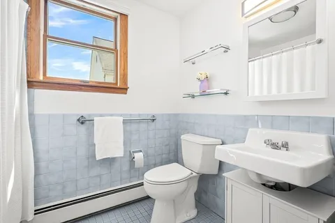 a bathroom with a sink a toilet and a mirror