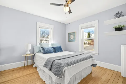 a bedroom with a bed and wooden floor