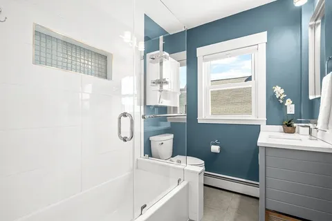 a bathroom with a bathtub sink and mirror